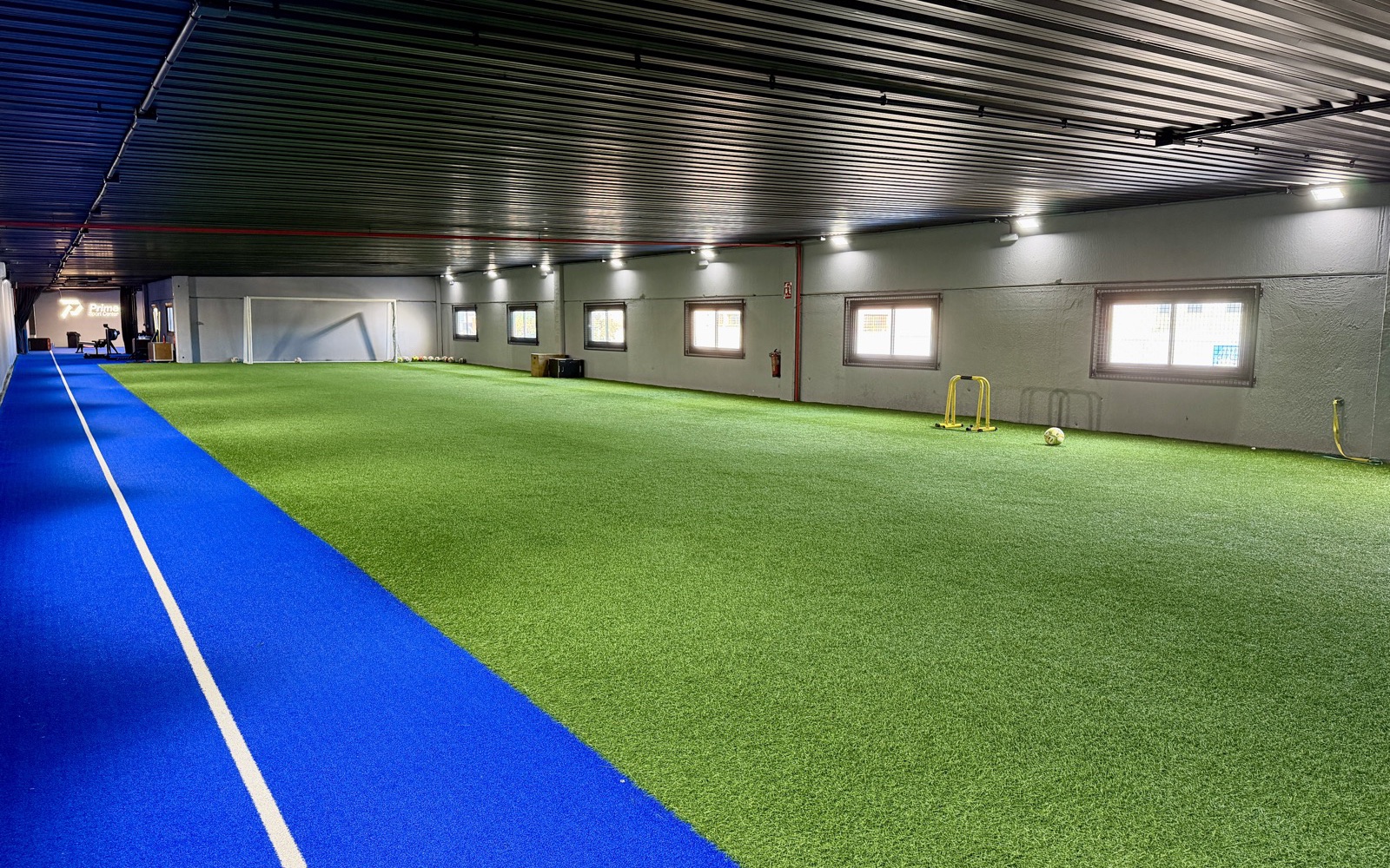 Campo interior de césped y pista de velocidad de la sede Móstoles Campo