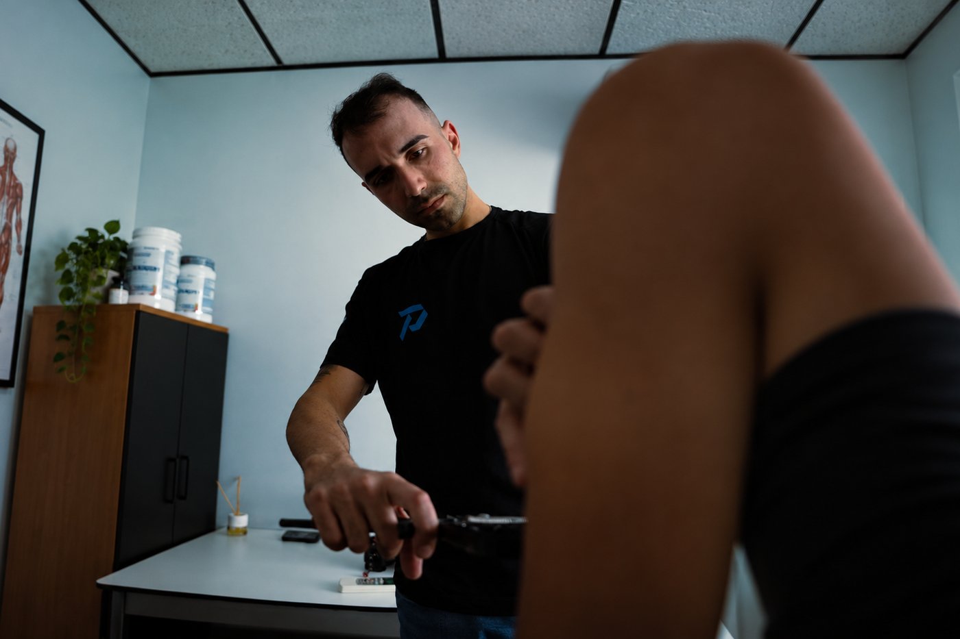 Profesional de Prime Sport Center explorando la pierna de un jugador en consulta