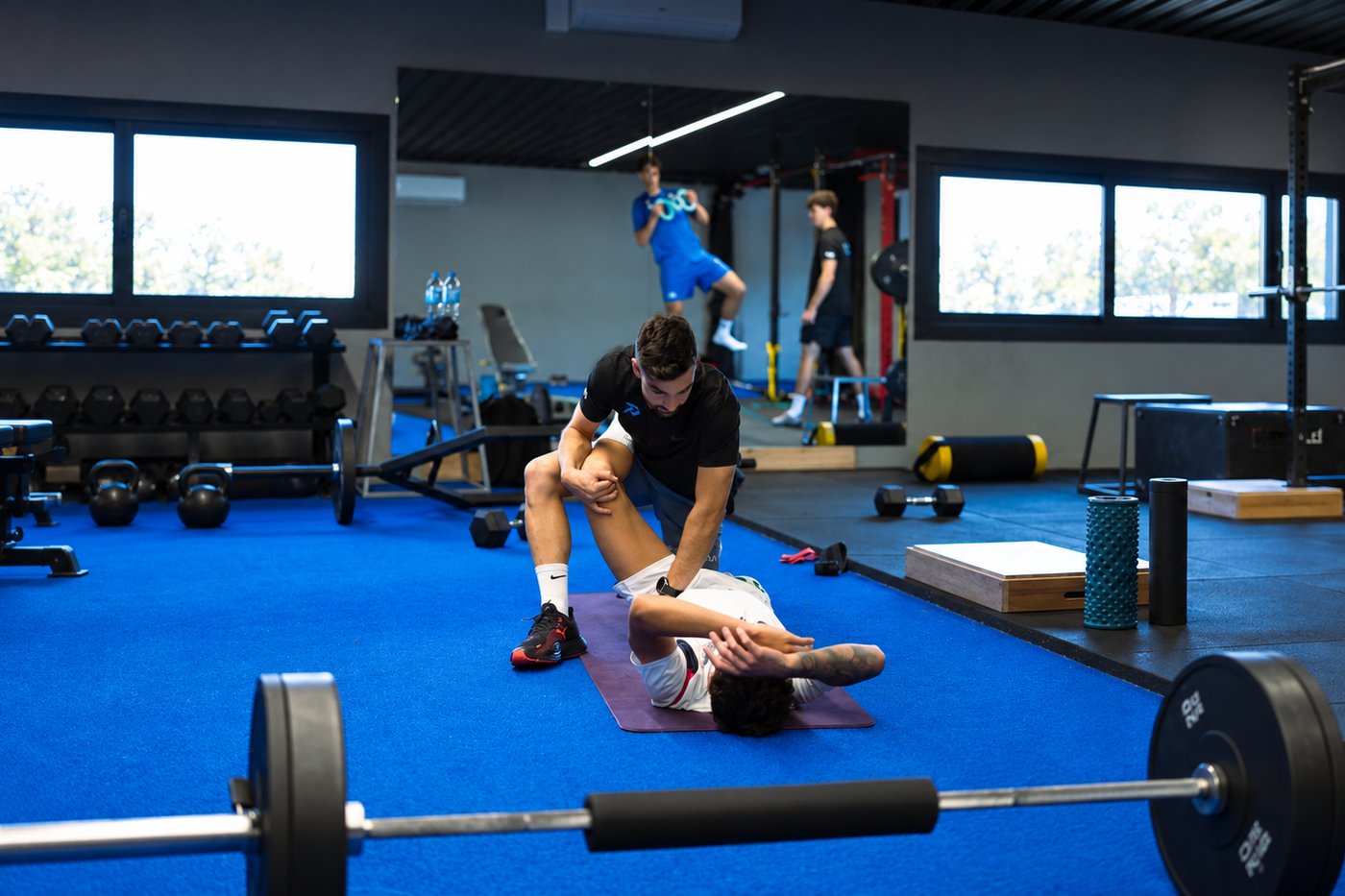 Entrenador movilizando la pierna de un jugador en la sala de Prime Sport Center